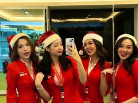 亚洲航空的几个戴着圣诞老人帽子的艳丽空姐